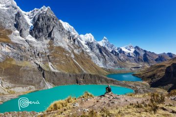 A hiker staring out at a lake in the Cordillera Huayhuash region