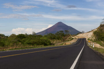 Tarmac road heading towards tall mountain