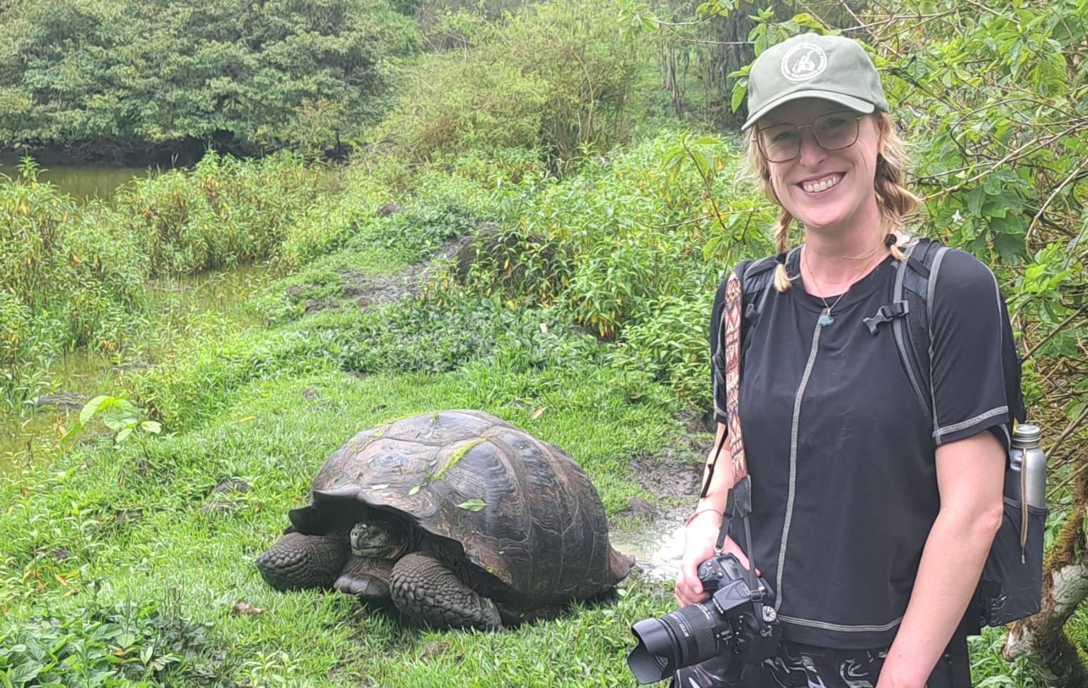 Travel Expert Maggie Wilson in the Galapagos with a giant tortoise.